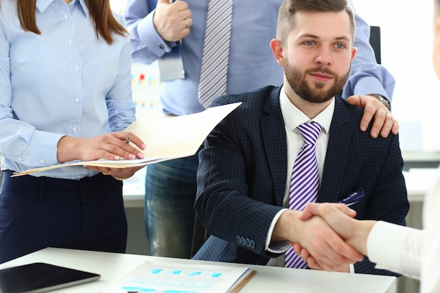 Grupo de empresários, apertando as mãos após reunião produtiva