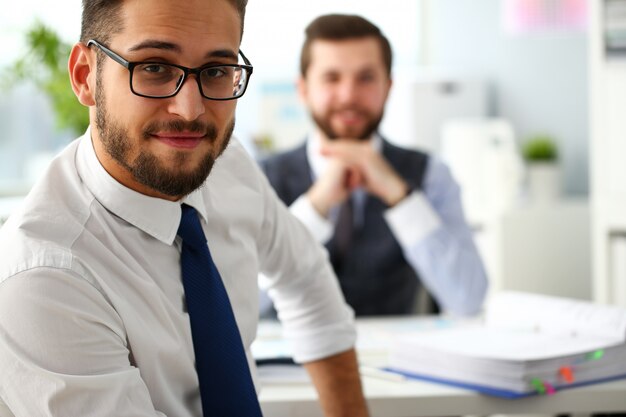 Grupo de empresários barbudos sorridentes de terno e gravata