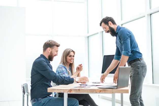 Grupo de empresários discutindo algo perto da mesa do escritório