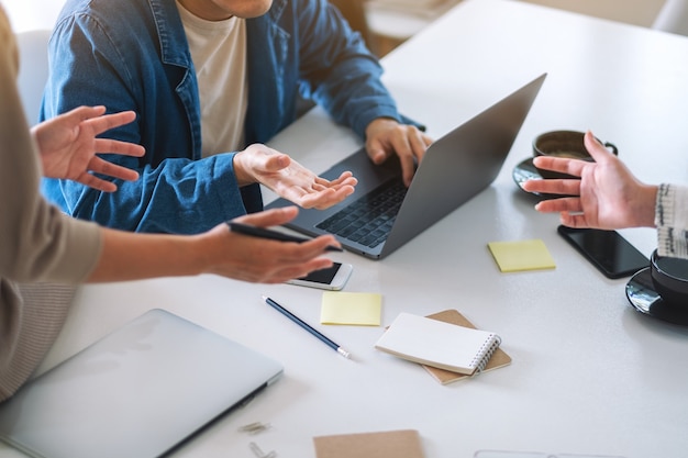 Grupo de empresários discutindo e trabalhando em um laptop sobre a mesa do escritório