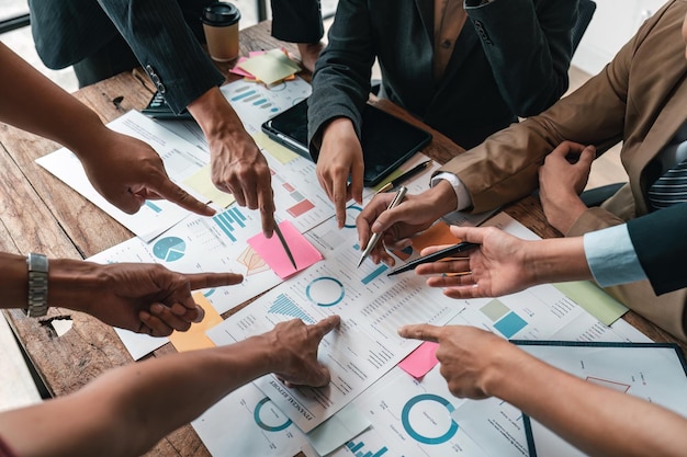 Grupo de empresários discutindo finanças e economia atuais na papelada de investimento da empresa na sala de reuniões