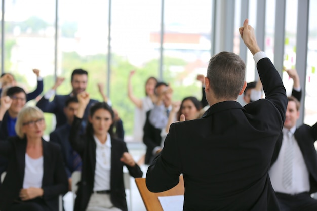 grupo de empresários em seminário ou reunião por foco na mão levantar