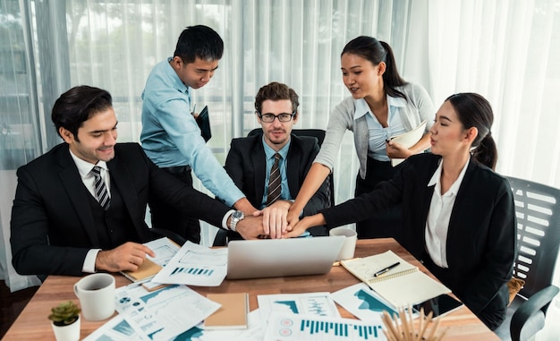 Grupo de empresários felizes em gesto comemorativo e trabalho em equipe eficiente e bem-sucedido Trabalhador de escritório de diversas raças comemora depois de progredir no planejamento de marketing no escritório corporativo Habiliment