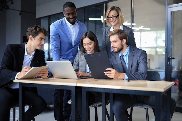 Grupo de empresários jovens felizes em uma reunião no escritório.