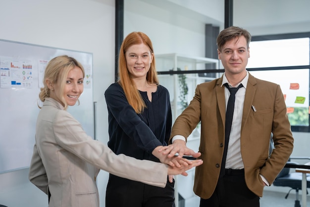 Grupo de empresários junta as mãos depois de conhecer o plano de negócios de brainstorming no escritório