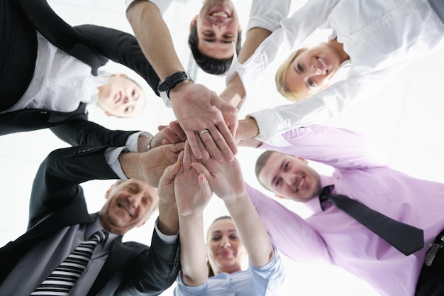 grupo de empresários juntando as mãos e representando o conceito de amizade e trabalho em equipe, vista de baixo ângulo