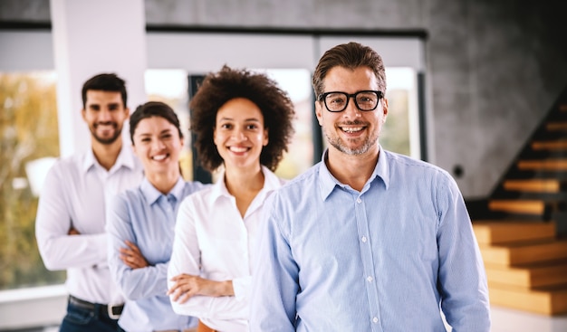 Grupo de empresários multiculturais posando. Interior da empresa corporativa.