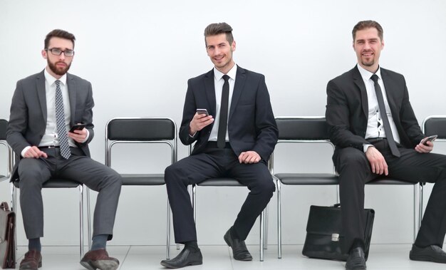 Grupo de empresários sentados no corredor do escritório
