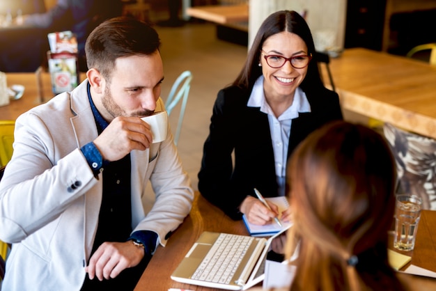 Grupo de empresários tendo conversa casual no café.