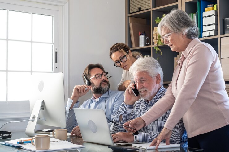 Foto grupo de empresários trabalhando e se comunicando, olhando para um laptop e um computador