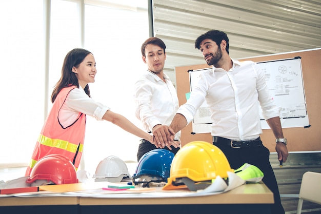 Grupo de engenheiros com juntar mão juntos no conceito de trabalho em equipe.