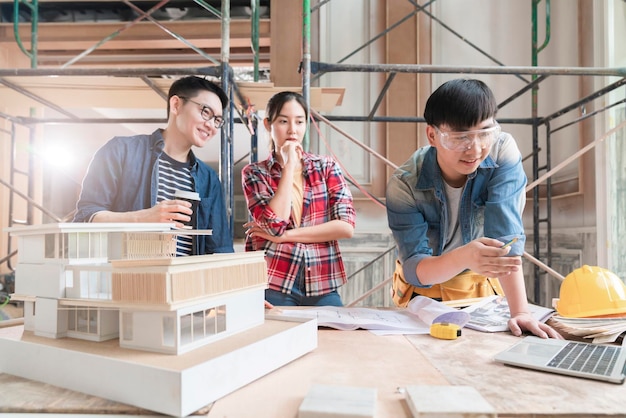 Grupo de equipe de design de interiores de arquiteto asiático inteligente, consultoria com engenheiro de construção, reunião de brainstrom com projeto de casa e maquete de casa em fundo de estrutura de renovação de casa