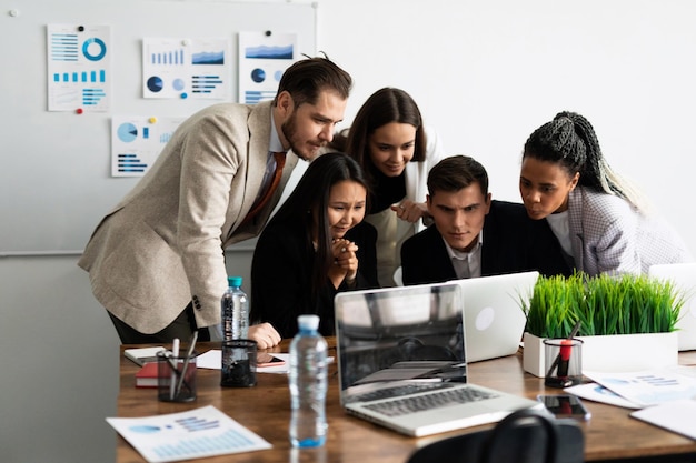 Grupo de equipe de marketing de jovens modernos em roupas casuais inteligentes discutindo algo durante o trabalho