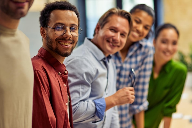 Grupo de equipe de sucesso de jovens negócios multiétnicos felizes olhando para a câmera e sorrindo