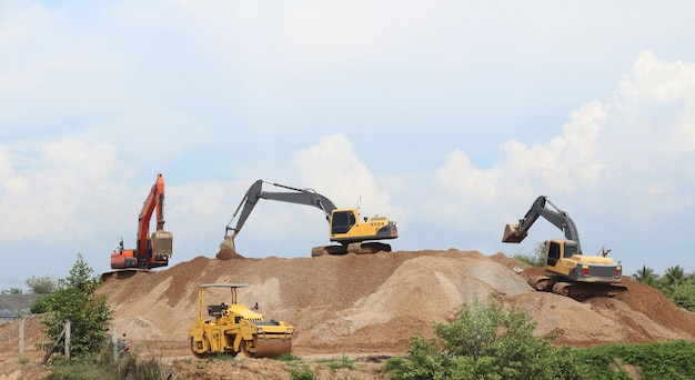 Grupo de escavadeira trabalhando no canteiro de obras no fundo do céu