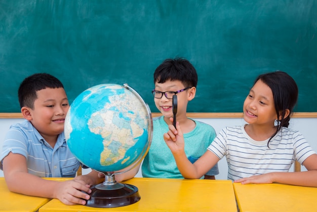 Grupo de estudantes asiáticos estudando geografia em sala de aula