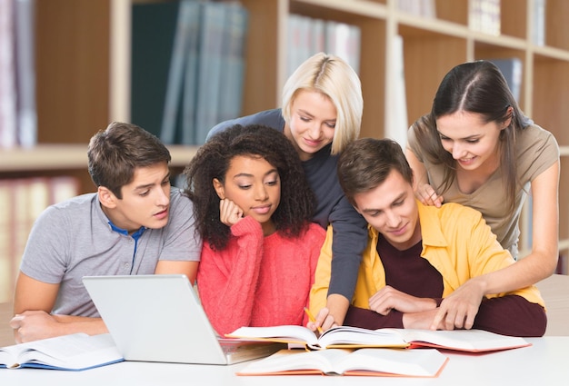 Grupo de estudantes com computador na aula em sala de aula