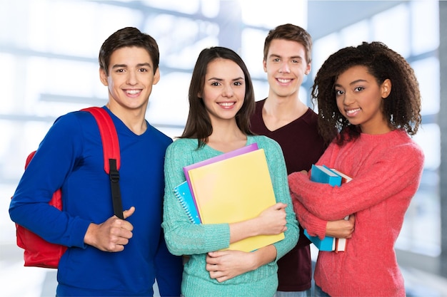 Grupo de estudantes com livros sorrindo para a câmera