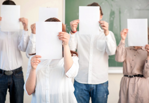 Grupo de estudantes com papéis em branco