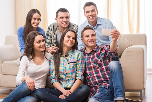 Grupo de estudantes com smartphones estão fazendo selfie.