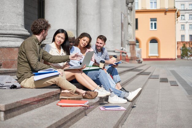 Grupo de estudantes com um laptop conversando após palestras