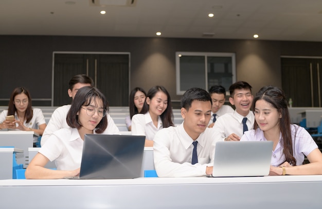 Grupo de estudantes que trabalham com laptop em sala de aula