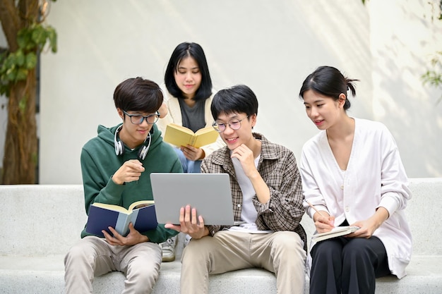 Grupo de estudantes universitários discutindo sobre seu projeto em uma área de relaxamento do campus juntos