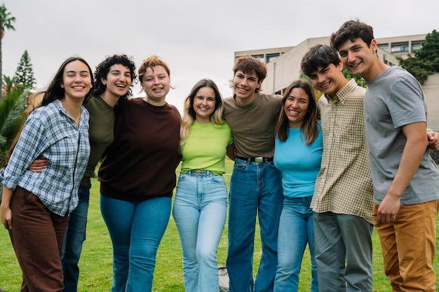 Grupo de estudantes universitários sorrindo para o campus da câmera