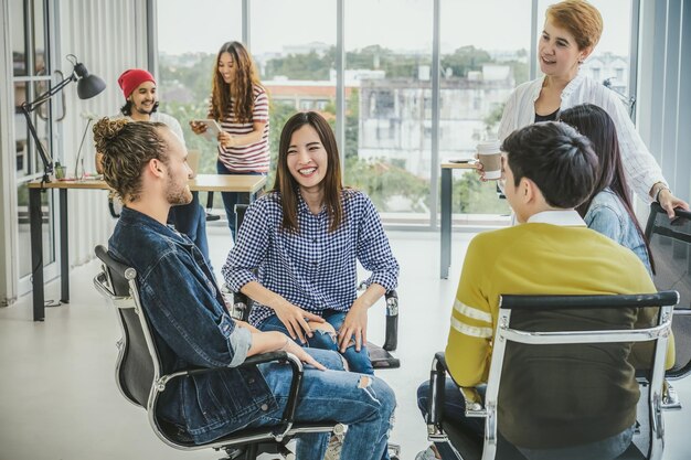 Grupo de executivos asiáticos e multiétnicos com terno casual em um feliz brainstorming de ação