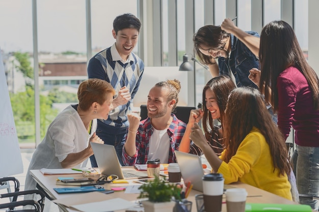 Grupo de executivos asiáticos e multiétnicos com terno casual trabalhando com ação feliz