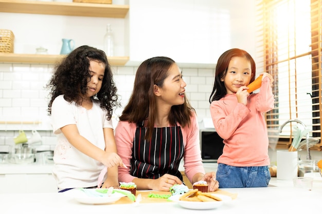 Grupo de família diversificada asiática e árabe pré-escolar criança árabe africana faz bolo cozinhando na cozinha mãe prepara decoração bonita com diversão educa no lanche bagunça de creme em todo o espaço da cópia do rosto