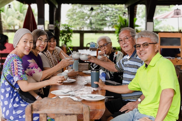 Grupo de família feliz almoçando e fazendo um brinde no restaurante