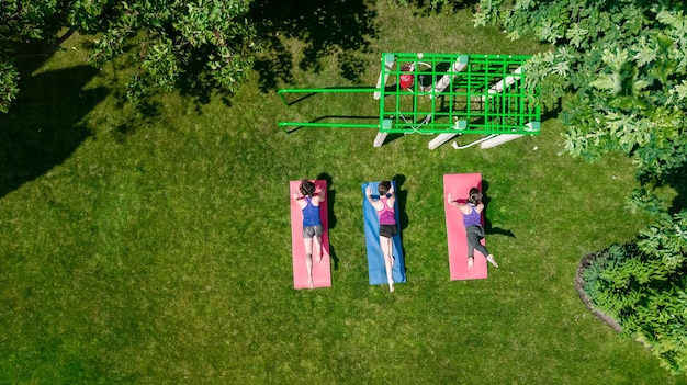 Grupo de fitness e esporte ao ar livre de meninas ativas fazendo exercícios no parque mulheres saudáveis se exercitando