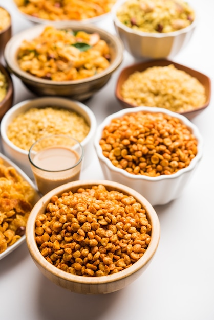 Grupo de floco de milho e poha chivda grosso ou chiwda e chatpata masala chana e moong dal crocante frito, servido em uma tigela. foco seletivo