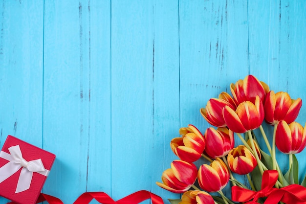 Grupo de flores de tulipa Conceito de Design do Dia das Mães Lindo buquê amarelo vermelho isolado no fundo de madeira azul vista superior espaço de cópia plana leiga