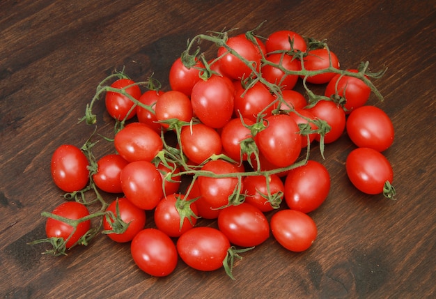 grupo de frescos tomates cereja vermelhos na madeira