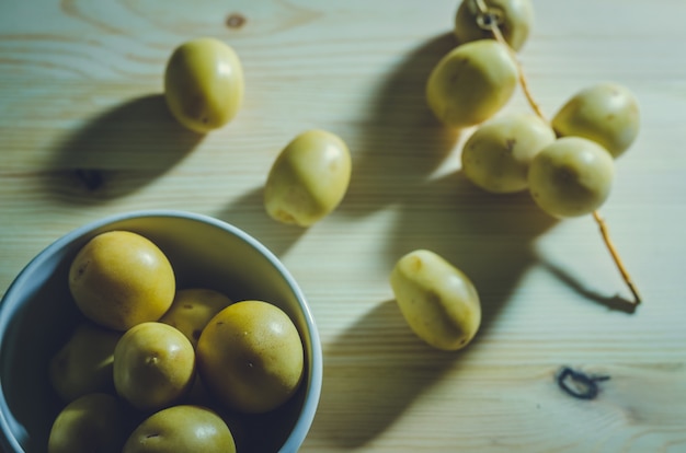 Foto grupo de frutas de tamareira frescas em fundo de madeira: estilo vintage