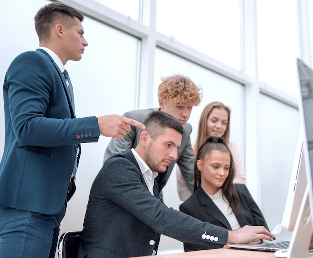 Grupo de funcionários lendo informações na tela do computador