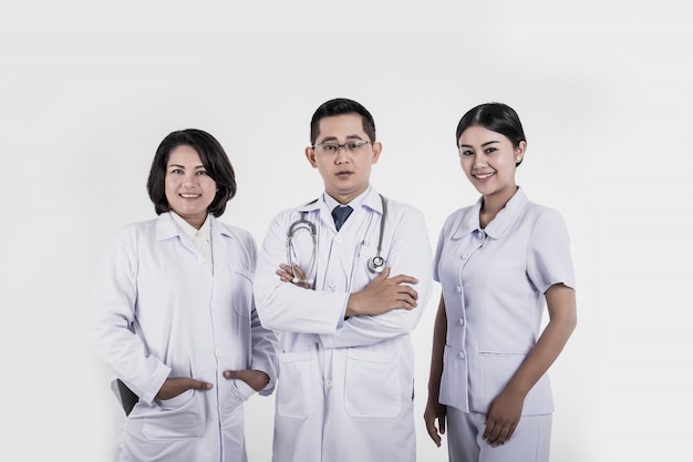 Grupo de funcionários médicos sorrindo de pé no hospital.