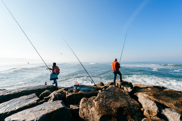 Grupo de homens adultos irreconhecíveis pesca