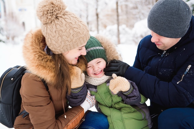 Grupo de homens e mulheres felizes se divertindo e brincando com a neve na floresta de inverno