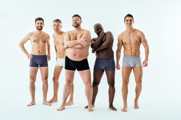 Grupo de homens multiétnicos posando para um conjunto de beleza positiva de corpo de edição masculina. Caras sem camisa com idade diferente e corpo vestindo cueca boxer