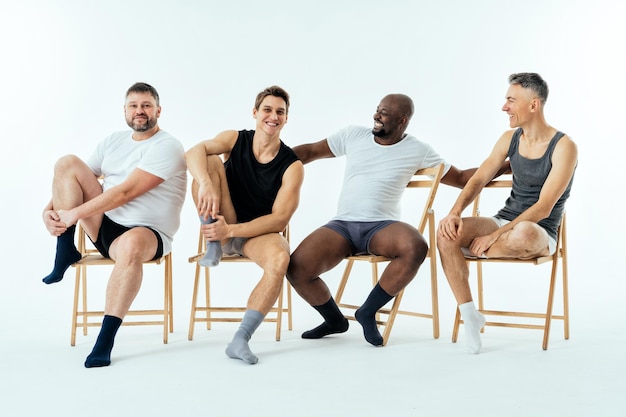 Grupo de homens multiétnicos posando para um conjunto de beleza positiva de corpo de edição masculina. Caras sem camisa com idade diferente e corpo vestindo cueca boxer