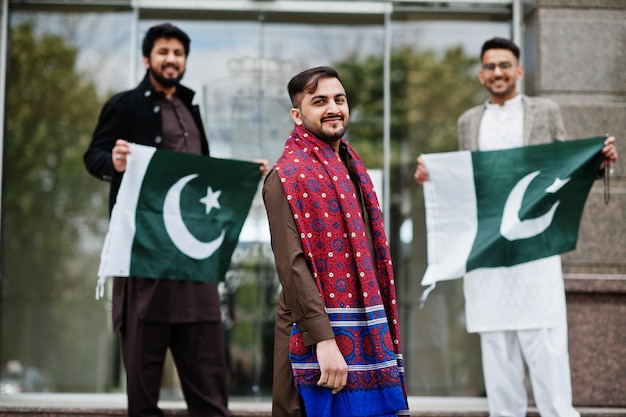 Grupo de homens paquistaneses vestindo roupas tradicionais salwar kameez ou kurta com bandeiras do paquistão