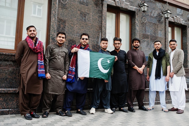 Grupo de homens paquistaneses vestindo roupas tradicionais salwar kameez ou kurta com bandeiras do Paquistão