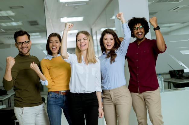 Foto grupo, de, jovem, excitado, pessoas negócio, com, mãos cima, ficar, em, escritório