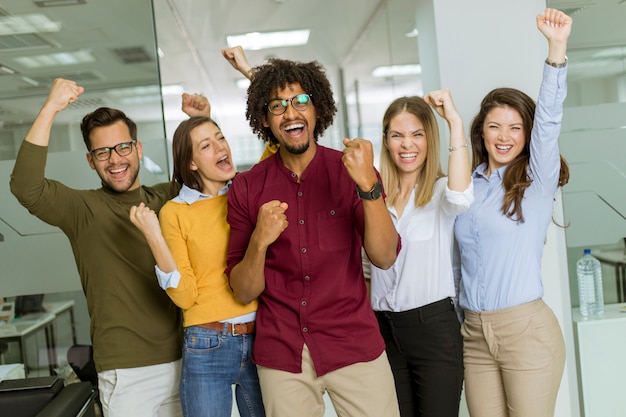 Foto grupo, de, jovem, excitado, pessoas negócio, com, mãos cima, ficar, em, escritório