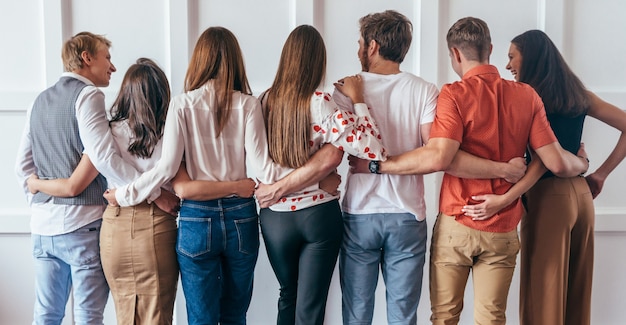 Grupo de jovens abraçando juntos Retrovisor.