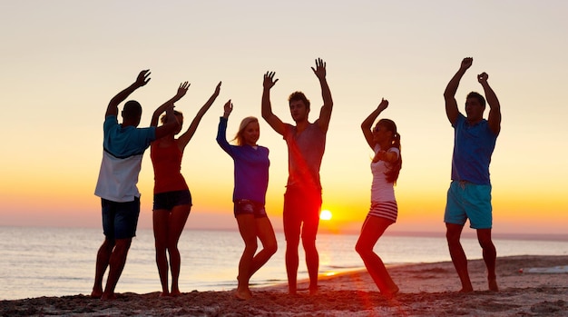 Grupo de jovens adultos festejando na praia