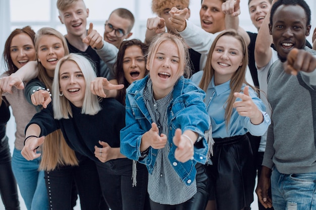 Grupo de jovens alegres apontando para você